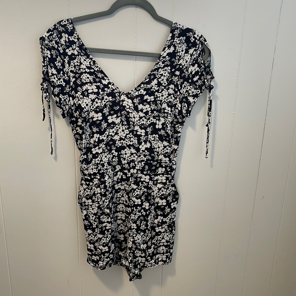 Express floral romper with pockets and back keyhole.